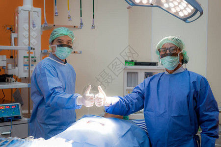 穿着成年制服和面具的外科医生团队在手术室里欢呼雀跃手术团队图片