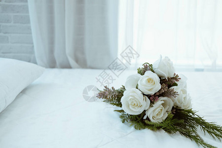 白新娘结婚玫瑰花束在床边的花束上图片