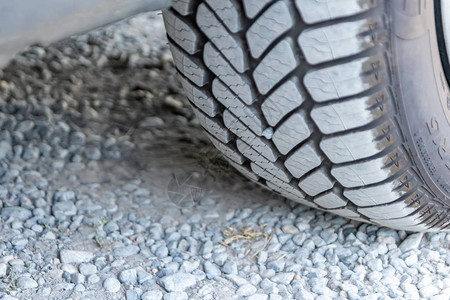 在尘土飞扬的石头路上用灰色尘清洁轮胎面轮廓图片