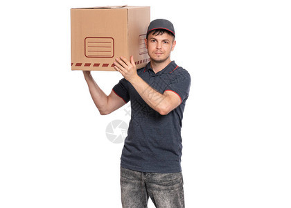 穿着帽子拿着大纸板盒的快递员肖像在看摄影机在白色背景上图片