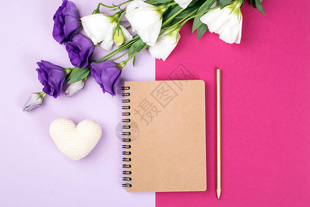 花卉小清新背景带笔记本的花卉模型鲜花和彩色纸背景上的空笔记本粉红色背景上的嫩eustonia花带复制背景