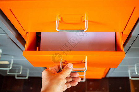 橙色金属色文件柜的女式手拉抽屉写信白皮书管理和存储特写镜头选择聚焦文图片