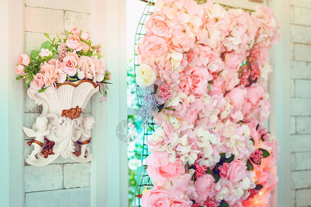 婚礼当天的背景墙上装饰着许多人造粉色和白色玫瑰美丽的花朵背景图片