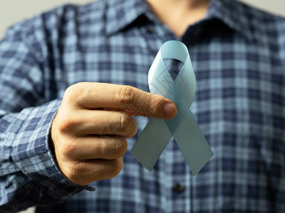一个穿格子衬衫的男人手里拿着一条蓝丝带这是前列腺癌意识的象征医学与人图片