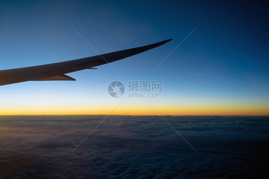 空中飞机翼飞越云层的景象和日出时飞过陆地自然和旅行概图片