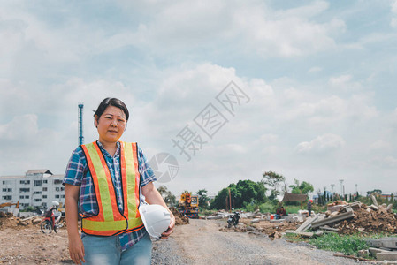 戴着头盔和安全背心的亚洲女土木建筑工程师或建筑师在建筑或建筑工图片