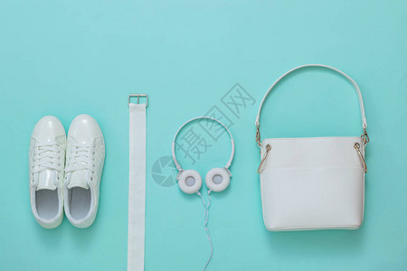 白色运动鞋白色耳机白色腰带和浅色背景上的白色包时尚女图片