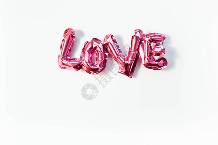 情人节的创意理念充气粉红色光泽箔气球字标志爱与孤立的白色背景上的阴影顶视图平躺与复制空间轻背景图片