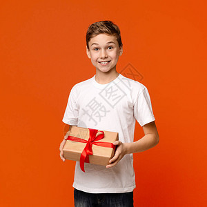 节日快乐快乐的少年男孩享受礼物盒橙图片
