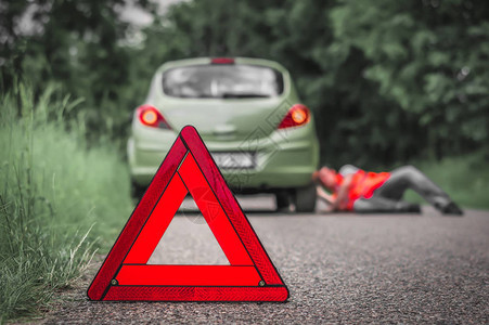 红色警告三角和在公路上撞坏的汽车图片