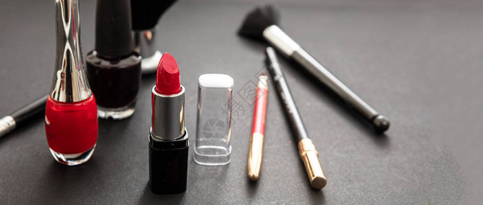 用红色和黑色组成化妆品黑色背景中的红色唇膏和指甲油图片
