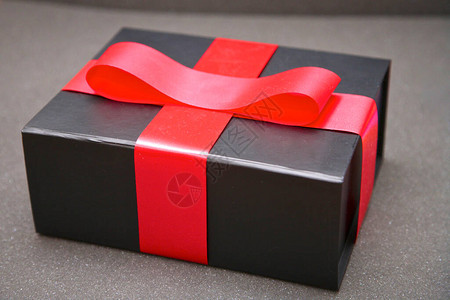 带红丝带的黑色礼物盒背景图片