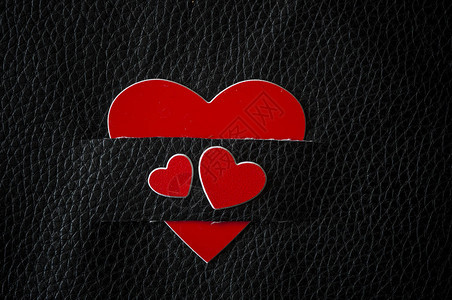情人节背景黑色皮革背景上的红心贺卡概念平躺顶视图片