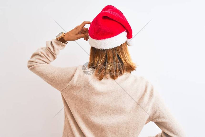 穿着圣诞帽子的漂亮红发美女与孤立的对着头部思考怀疑的反面图片