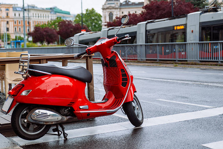 城市街道的红色时尚小摩托车在雨后背景图片