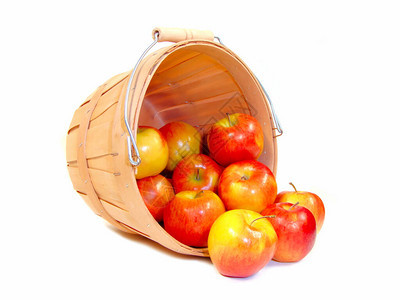 从木制农民篮子上溢出的苹果以白色图片