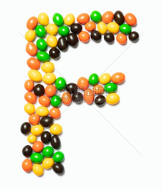 英文字母F来自白色孤立背景上的彩色圆形巧克力由儿童糖果制成的食物图案儿童设计图片