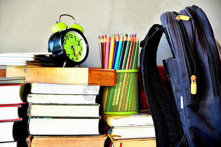 书本书包学校背包闹钟彩色铅笔桌边的滑板收藏图片