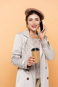 秋天时装的时髦女人一边喝咖啡边去一边聊着在桃子上隔图片