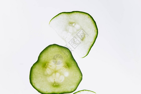 明亮的白光特写背景上的绿色半透明黄瓜片透明的蔬菜盘宏观中万花图片