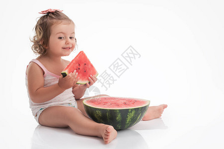 婴儿女孩吃西瓜切片孤图片