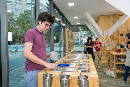 在零废品商店的年轻男直升机批量购物图片