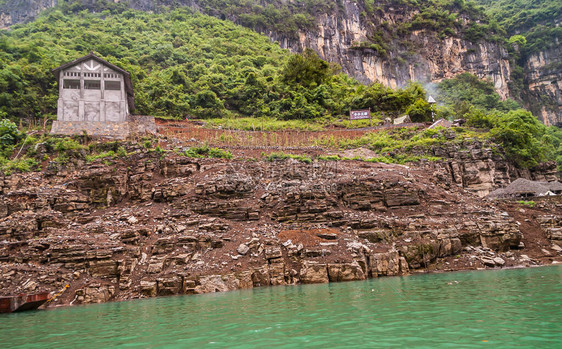 迷你三峡灰色的水泥谷仓建在大宁河棕色石头海岸线上图片