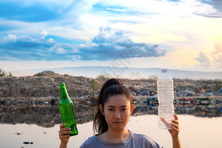 一名妇女手持绿色玻璃瓶和透明塑料瓶图片