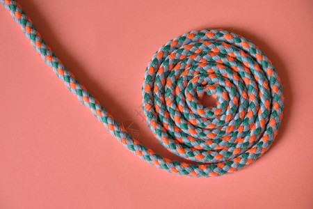 绳子螺旋在粉红色表面的边缘滑落图片
