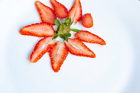 草莓片在花形的白盘上展开图片