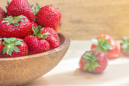 木碗中的新鲜美草莓木桌图片