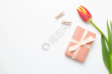 白色背景上带有红色郁金花的礼品盒Flor构成平板层顶视图图片