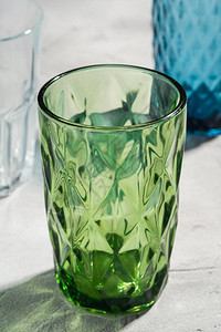 绿色玻璃几何杯靠近蓝色和透明饮料杯图片