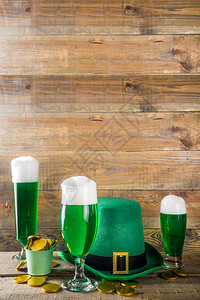 圣帕特里克节派对的传统爱尔兰酒不同的玻璃杯配绿色啤酒巧克力硬币装饰和绿色妖精帽子古朴的木质图片