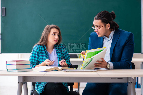 年轻英俊的教师和教室中的女学图片