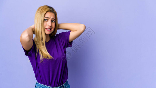 年轻金发女郎在紫色背景中被孤立在脑后触摸思图片