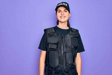 身穿防弹衣的年轻女警察穿着紫色背景的防弹衣图片
