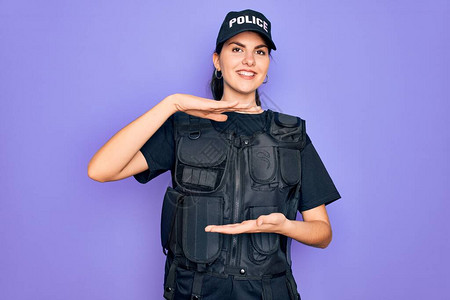 身穿紫色背景安全防弹背心制服的年轻女警用双手展示大小的标志背景