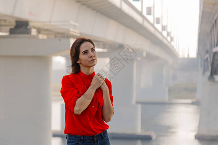 美丽的女孩站在河边的桥上图片