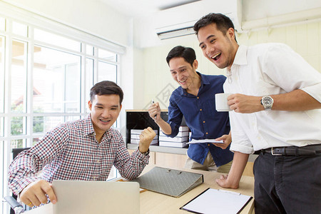 快乐的商务人士组一群商务人士在电脑前欢呼办公室里的人兴图片