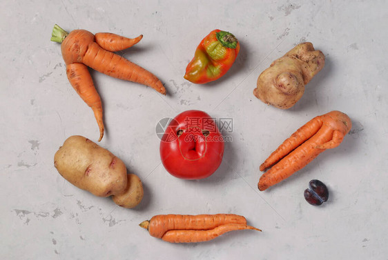 灰色背景的土豆胡萝卜番茄辣椒和李子丑陋食品概图片