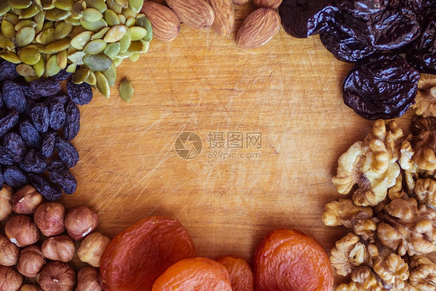 不同品种的去皮坚果南瓜籽和干果放在木板上图片