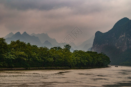 沿漓江灰色云景下大范围喀斯特山脉前海岸线上的绿叶景观银河上地图片