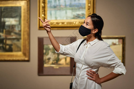 在历史博物馆里妇女参观者佩戴抗面背景图片