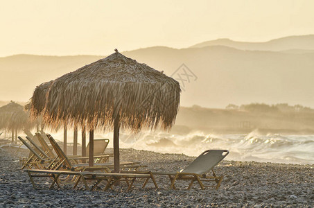 希腊草沙滩伞日落图片