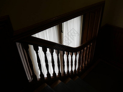 在新英格兰的一栋旧宅邸里由楼梯飞翔穿过窗帘的自图片