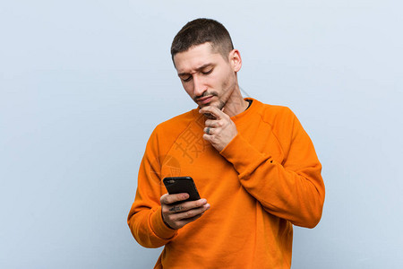 年轻caucasian男子拿着手机图片素材