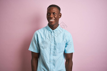 身穿蓝色轻便衬衫的非洲美国人站在孤立的粉红色背景上图片