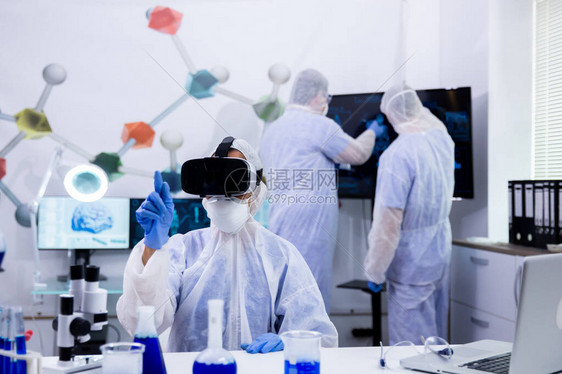 带着虚拟现实护目镜在现代实验室进行化学测试的科学家试管图片