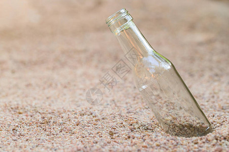 沙子上的空玻璃瓶垃圾污染概念图片